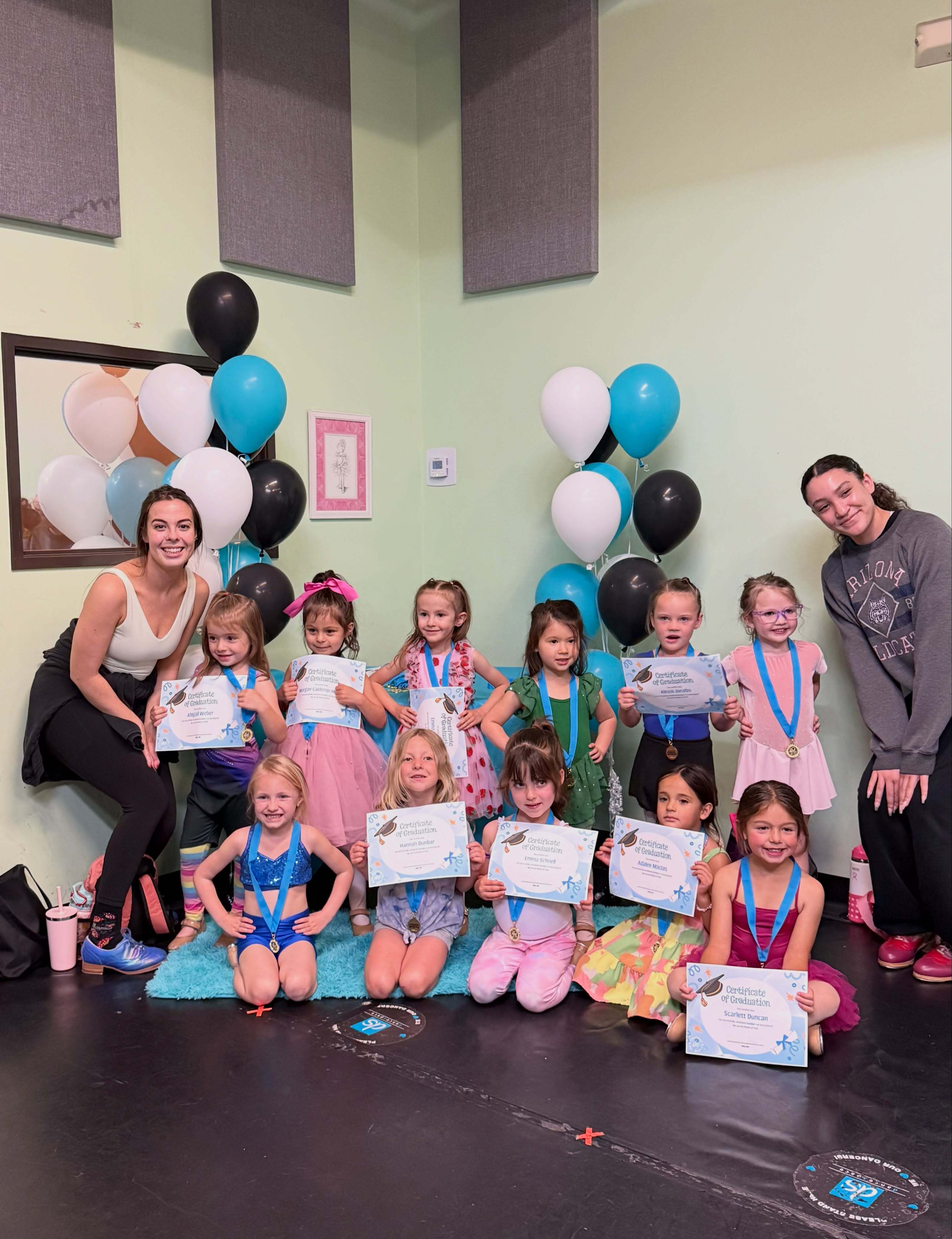 DanceSpace teaching assistants with a class of young dancers holding graduation certificates